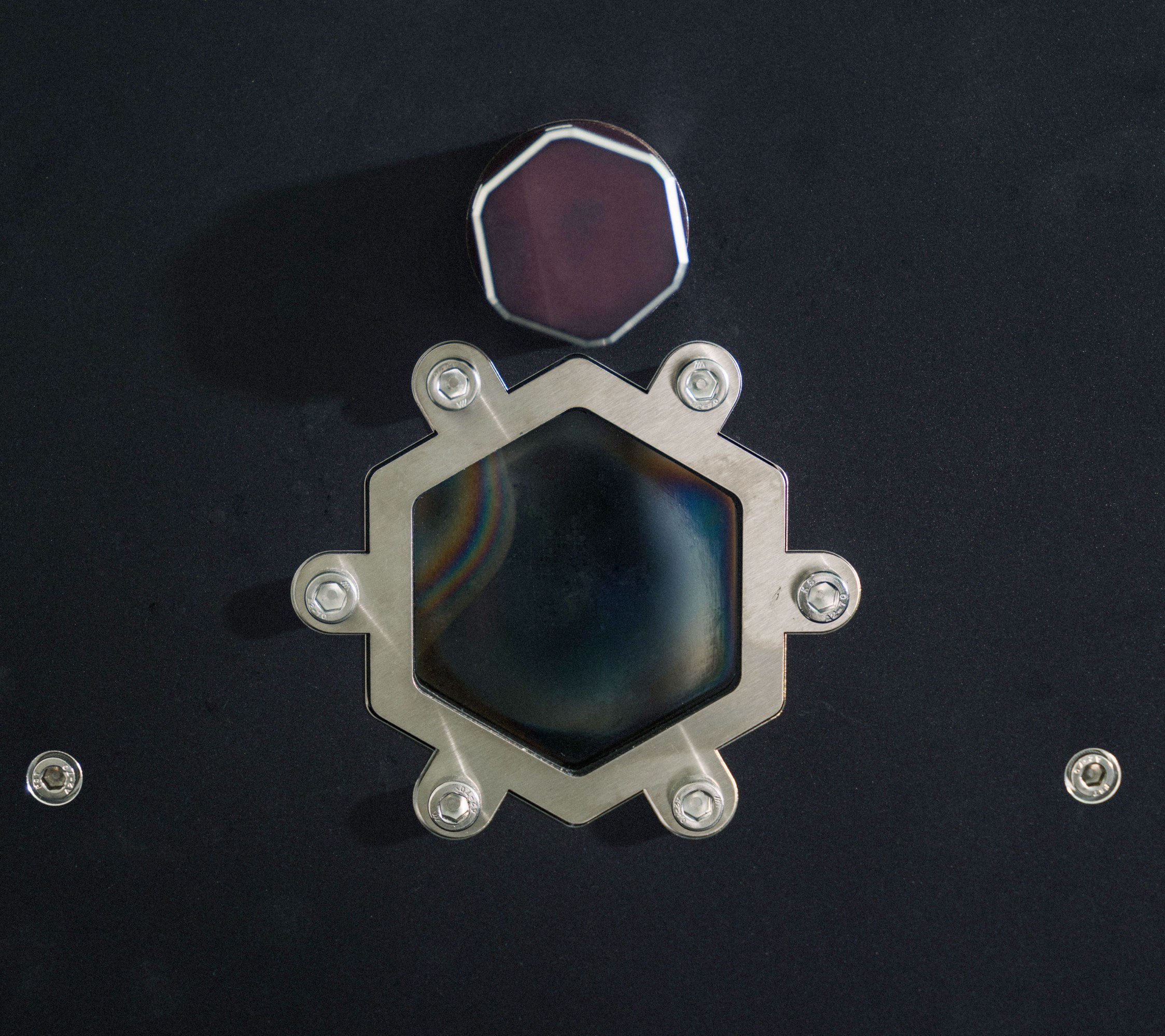A hexagonal window in the side of a black box