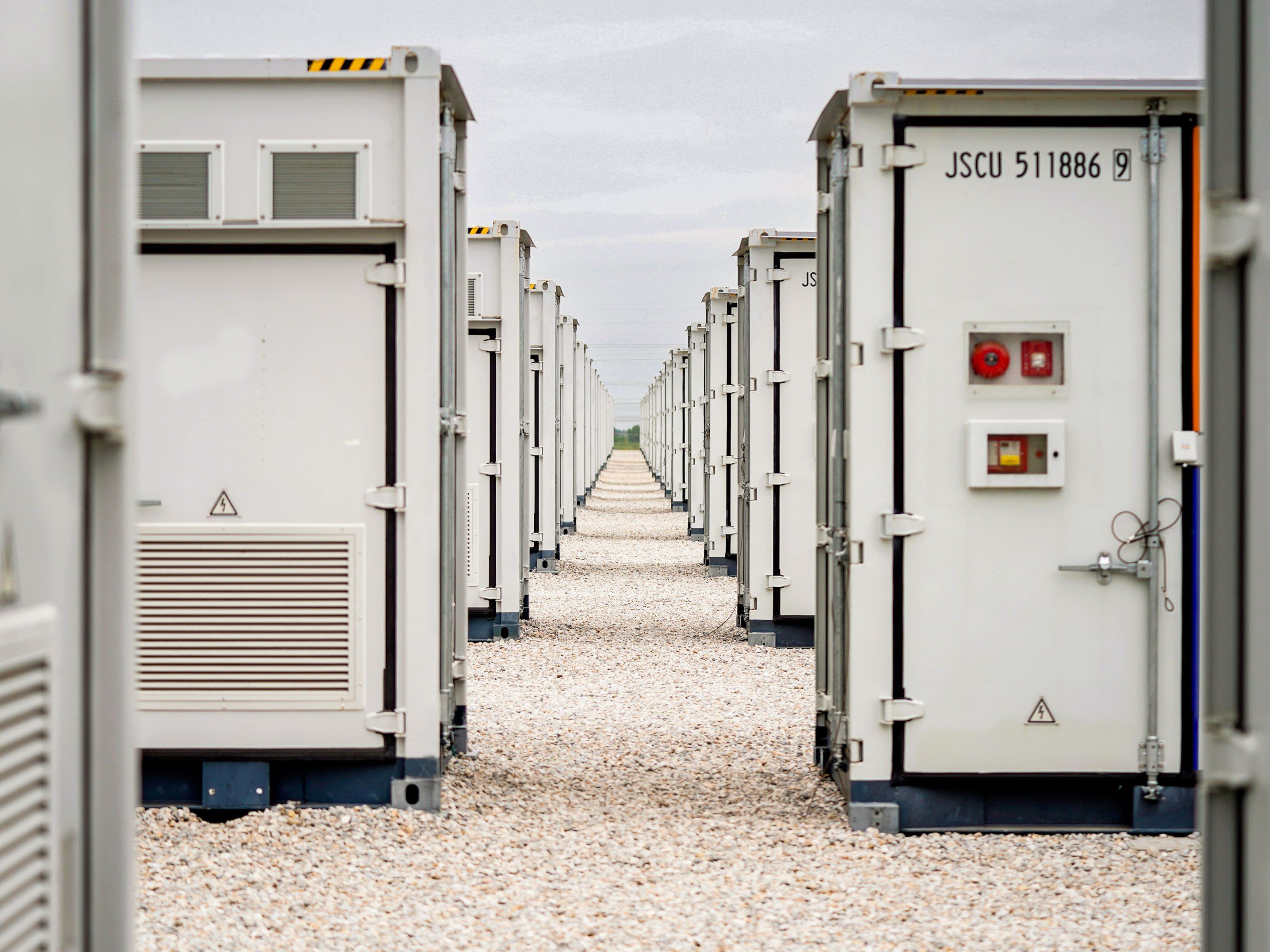 looking down a row on battery storage units on an overcast day