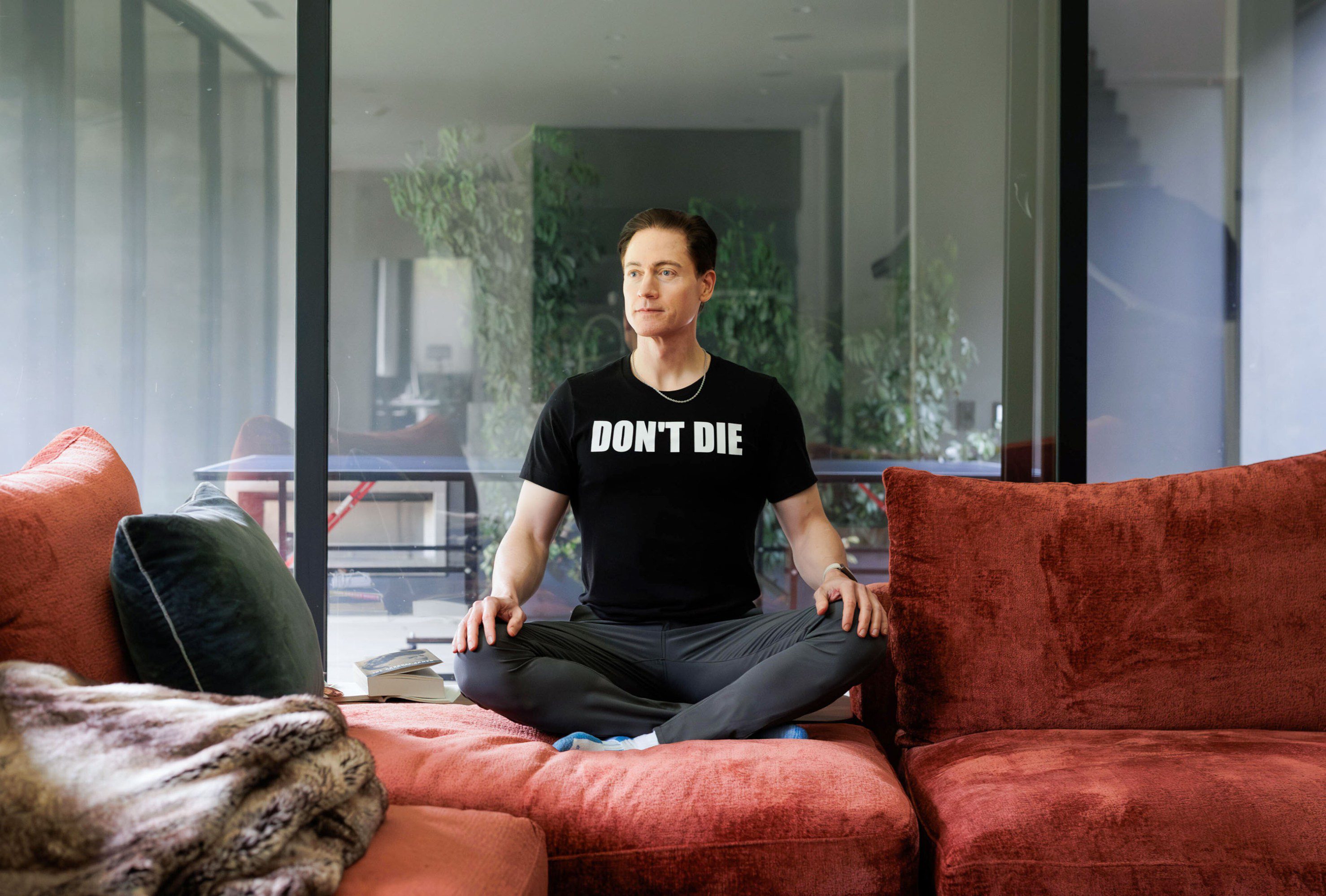 Bryan Johnson sitting cross-legged at home