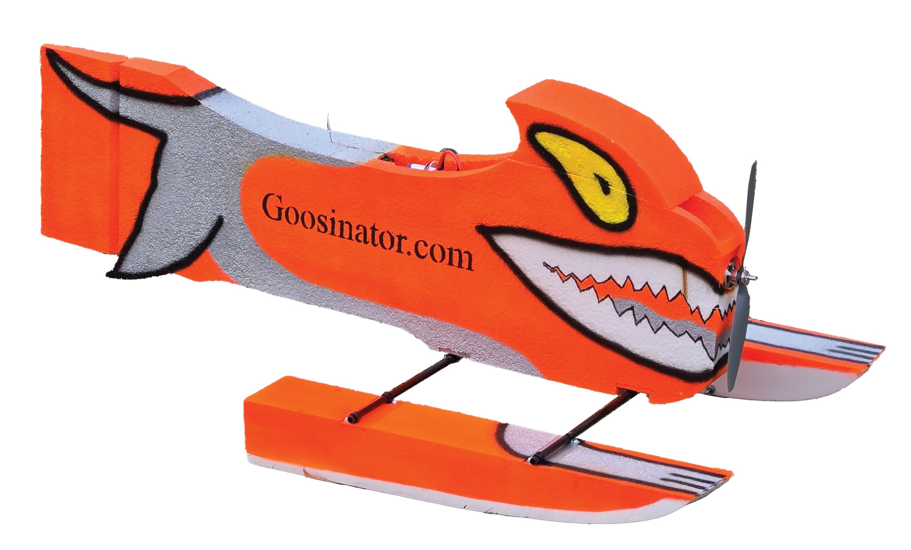 An orange foam pontoon boat with yellow eyes and sharp-looking jagged teeth